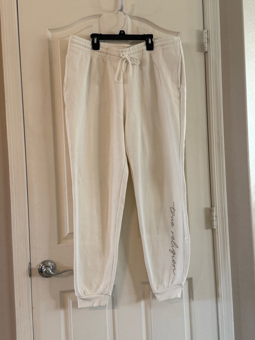 True Religion has Cream Jogger Sweatpants with rhinestone Side Script
